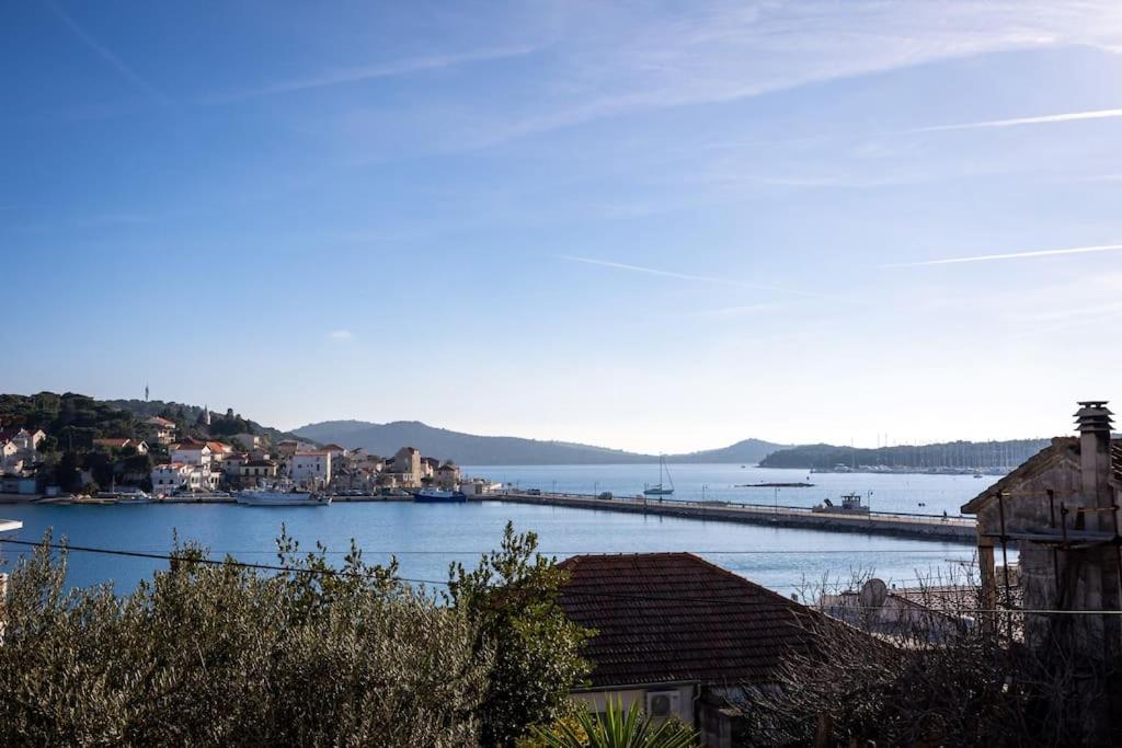 View over rooftops and olive trees towards the bay