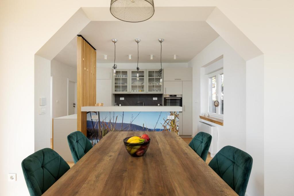 Dining table with green chairs beside the kitchen
