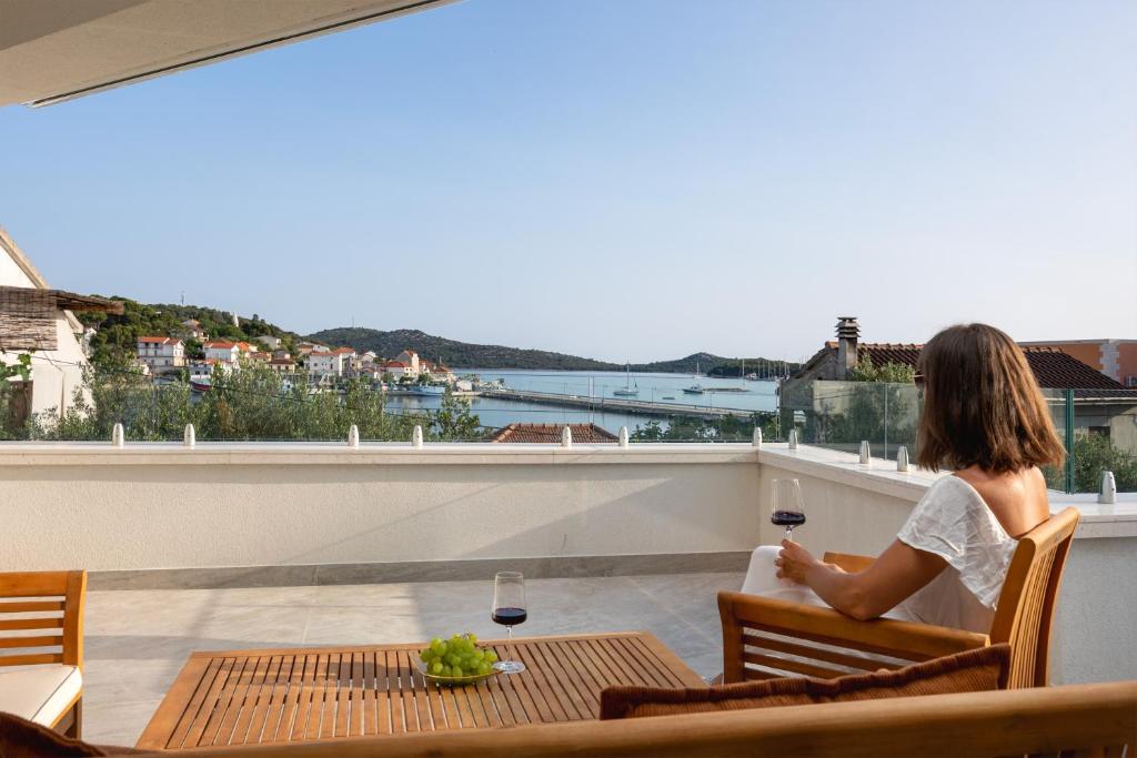Guest enjoying wine on the terrace above the bay